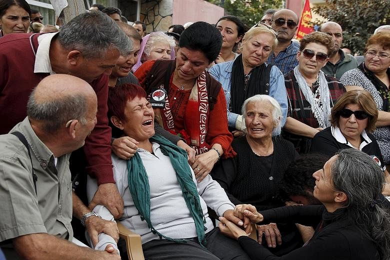 Family members of a victim of last Saturday's bomb blasts mourning over his coffin during a funeral ceremony in Ankara, Turkey, on Sunday. Ninety-seven people were killed in the attack targeting a major peace rally. It never took place.