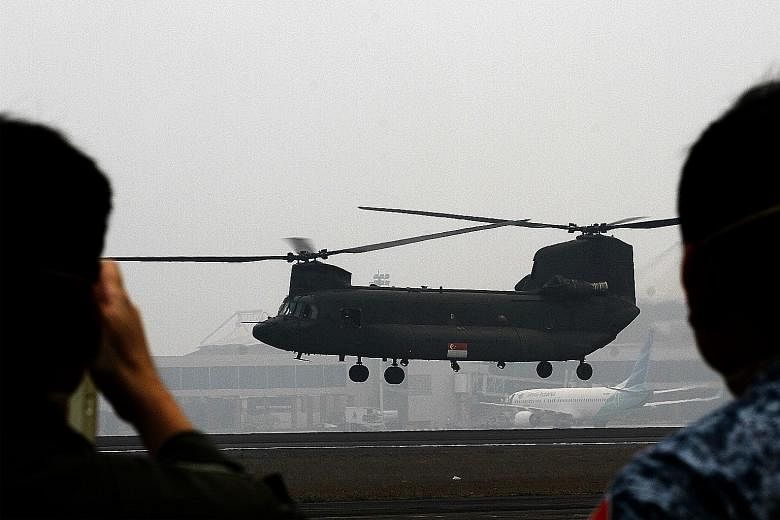A Republic of Singapore Air Force Chinook helicopter, carrying a crew of Singapore military and civil defence personnel, takes off from the haze-covered Indonesian airbase in Palembang, Sumatra, on Monday, for its first aerial water-bombing mission o