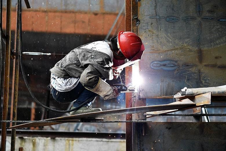 A worker welding a part of a cargo ship in a shipyard in China's south-west Chongqing municipality. Chinese imports slumped by 20.4 per cent in September from a year earlier, posting an 11th straight decline.