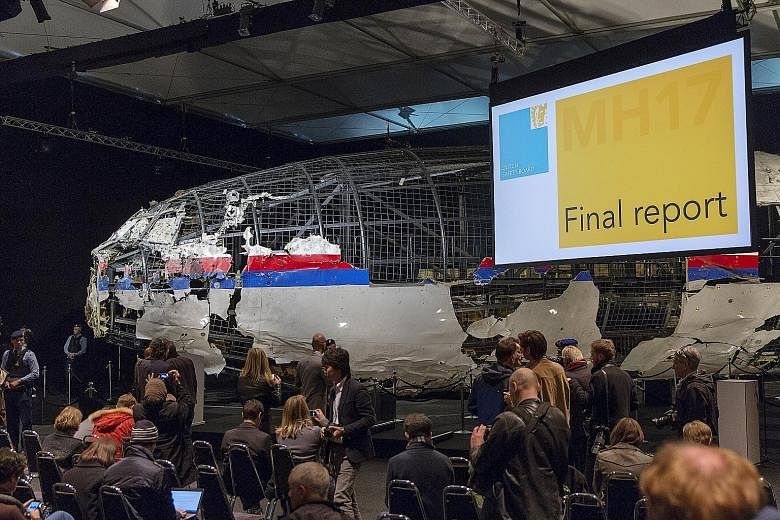 The reconstructed aeroplane serving as a backdrop during the presentation of the final report into the crash of Malaysia Airlines Flight MH17 in Gilze-Rijen, the Netherlands, yesterday. The report by an international team of investigators led by the 