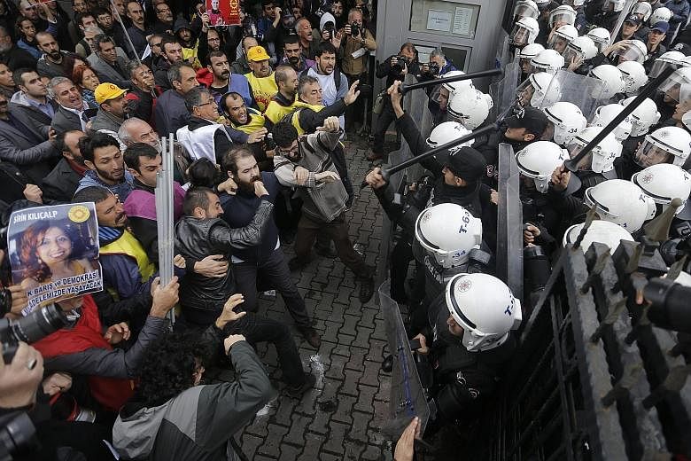 Protesters clashing with Turkish riot police during an anti-government demonstration in Istanbul yesterday. Turkish investigators were seeking to firm up suspicions that members of the Islamic State in Iraq and Syria were behind the double suicide bo