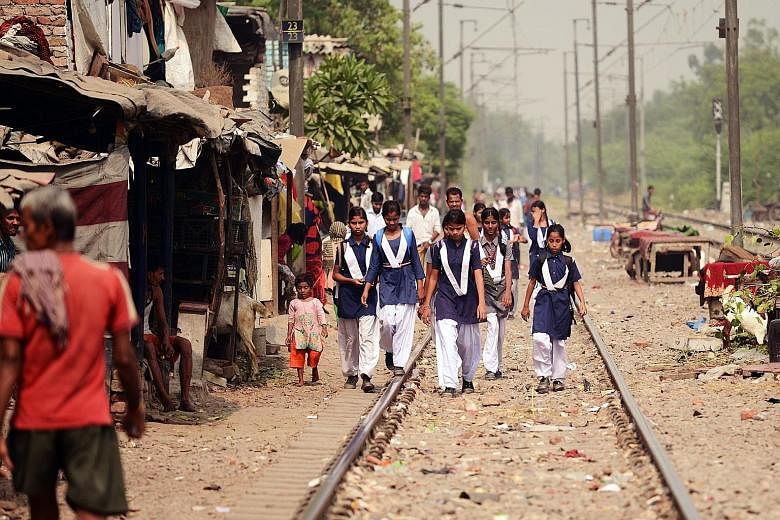People at the railway tracks near a slum area of New Delhi yesterday. The four-year-old girl who was raped was found unconscious with her face and body slashed on the tracks last Friday.