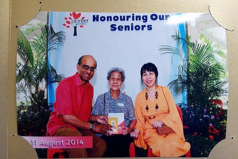 Madam Khoo Bee Hua (centre) receiving her Pioneer Generation card from Deputy Prime Minister Tharman Shanmugaratnam in August last year. With them is Mrs Tharman. Mr Tharman, who visited Madam Khoo in hospital yesterday, called her the "archetypal pi