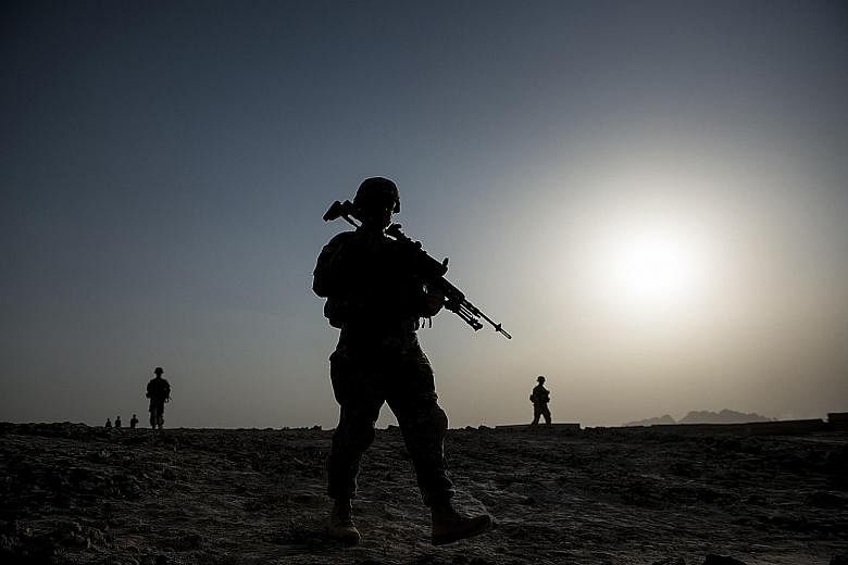 US soldiers on patrol near Kandahar Airfield in Afghanistan in a 2014 photo. US President Barack Obama is giving up on his hopes of bringing nearly all American troops home from Afghanistan by the end of his term in January 2017. The shift in plannin