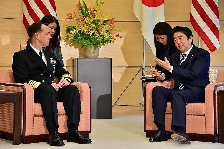 US Chief of Naval Operations John Richardson with Japanese Premier Shinzo Abe during a meeting at Mr Abe's office in Tokyo yesterday. Admiral Richardson is in Japan at the start of a 12-day trip around Asia and Europe.