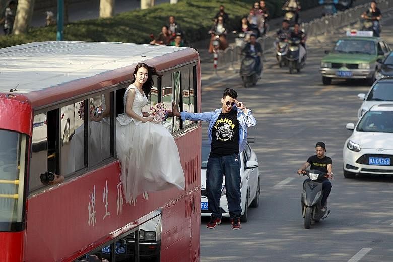 Chinese magician Lei Xin suspended outside a double-deck bus next to a woman in a wedding gown during a magic performance in Zhengzhou, Henan province, on Thursday. The performance, organised by Lei and his friends, was aimed at promoting a healthier