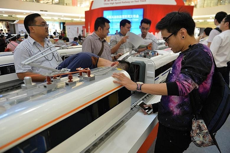 Visitors looking at models of Chinese-made bullet trains on exhibition at a shopping mall in Jakarta. Chinese and Indonesian state-owned companies will jointly build the first high-speed railway in Indonesia.