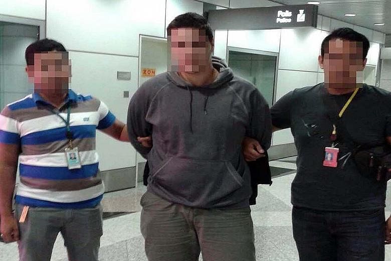 Malaysian police said they have arrested a man (centre), identified by the US as Kosovo citizen Ardit Ferizi, who is wanted for allegedly stealing data related to more than 1,000 US military and government personnel and providing the information to I