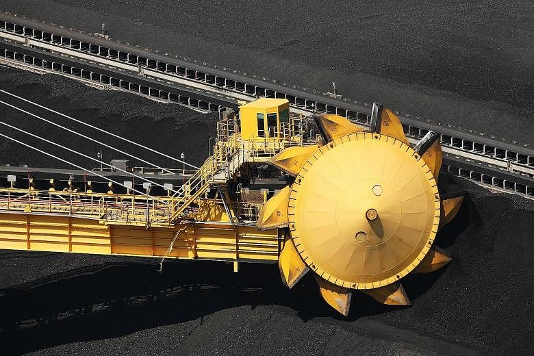 (Top) A stacker reclaimer at the Newcastle Coal Terminal in Australia. The global economic slowdown is exacerbating a coal glut that has driven prices for the fuel to the lowest level in eight years, according to Glencore. Its CEO Ivan Glasenberg (ab