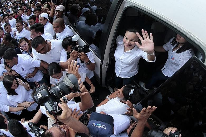Leading contender Senator Grace Poe (top, right) waving to supporters after filing her certificate of candidacy in Manila on Thursday. The presidential election is scheduled for May next year.