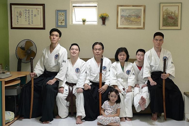 Mr Patrick Chan, 56, (third from left) and his wife Lily Cheok, 63, with their sons (from left) Shamus, 29; Sean, 25; Enoch, 23; and Jonah, 24. Shamus' four-year-old daughter, Cassiel, is sitting on the floor. Aikido is a family affair for the Chans,