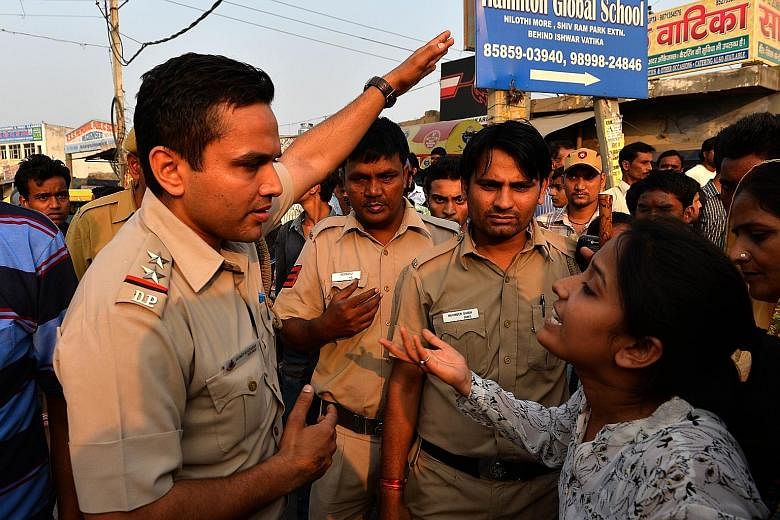 A woman shouting at a policeman during a protest near the home of the toddler who was abducted and raped.