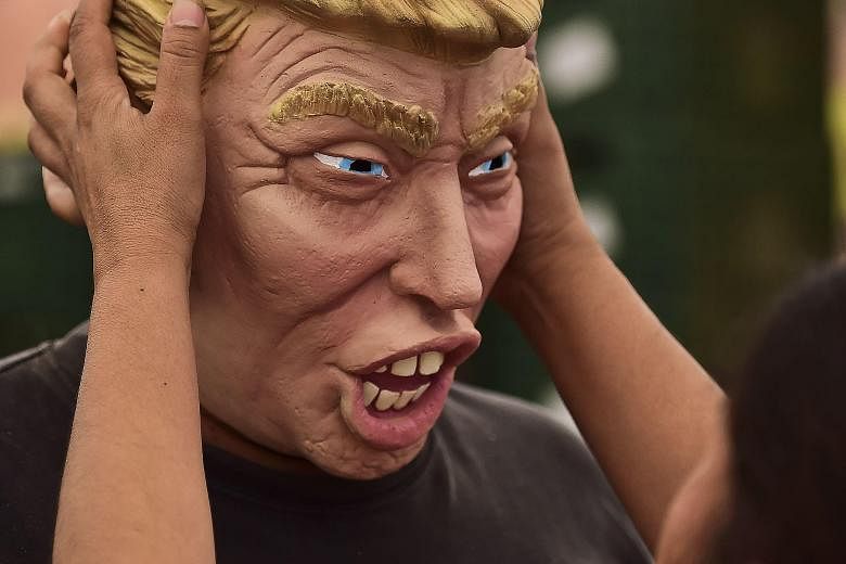 A factory worker checks the production of a Donald Trump mask recently in Mexico. Mr Trump's tendency towards controversial rhetoric has not hurt his ratings so far, with polls of Republican voters showing he leads the 15-candidate field.