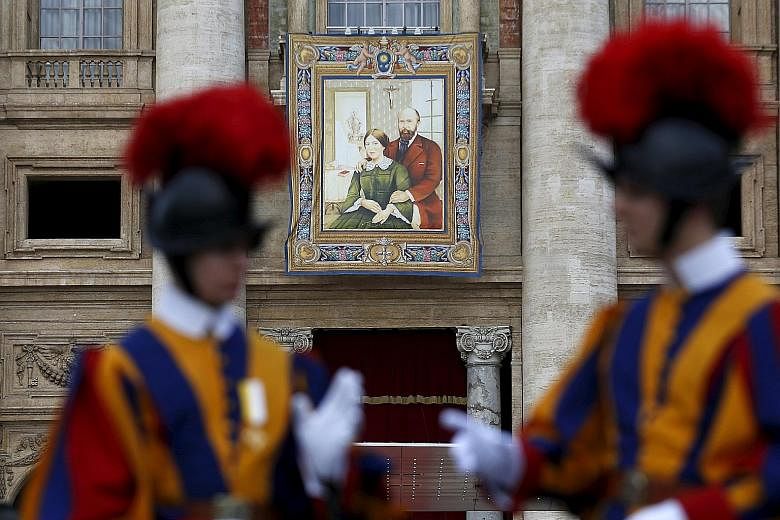 A tapestry showing Louis Martin and Marie Azelie Guerin Martin, parents of St Therese of Lisieux, hanging from a balcony of the Vatican as Pope Francis celebrated the mass for their canonisation in St Peter's Square yesterday.