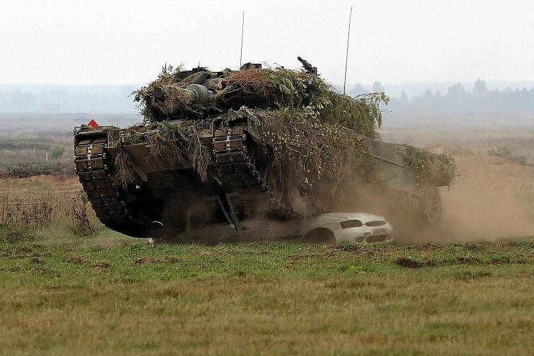 A Leopard 2 battle tank crushes a car during a Nato exercise in Poland's Masuria region last week.