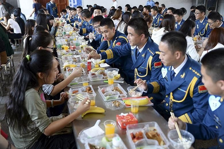 Soldiers from the Chinese People's Liberation Army air force chat with young women over lunch at a military base in Wuhan, Hubei province. More than 200 women participated in the matchmaking event last Saturday, local media reported. The government b