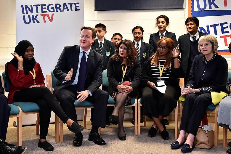 British Prime Minister David Cameron and Home Secretary Theresa May (far right) speaking with students during a visit to Luton yesterday to announce the new government strategy for tackling radicalisation.