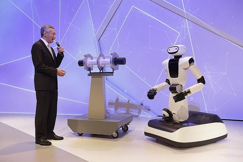 Prime Minister Lee Hsien Loong interacting with Olivia the robot, developed by A*Star's I2R, at the official opening of the $450 million Fusionopolis Two at one-north's R&D hub yesterday.