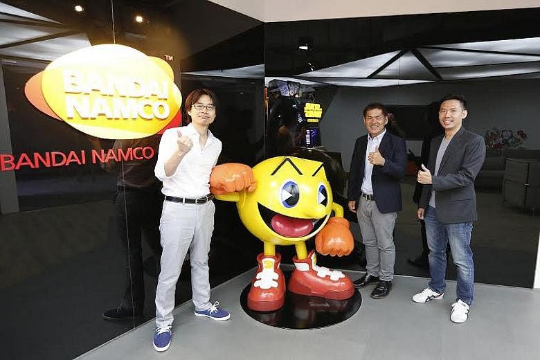Japanese game-maker gumi Asia's Wakfu Raiders (above, left and right) was made in Singapore. Bandai Namco Studios Singapore's managing director Makoto Ishii (centre, with producer Takashi Ohwaki and senior producer Ian Pang, right) says there are pla