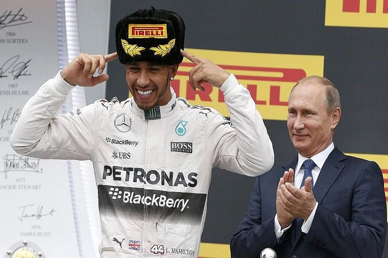 Russian President Vladimir Putin on the podium in Sochi with Lewis Hamilton on Oct 11, after the Mercedes driver clinched his second straight Russian Grand Prix. Come Sunday, the Briton will be hoping that instead of a Russian fur hat, he will be don