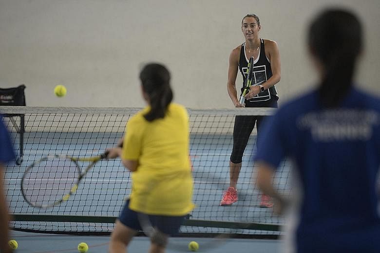 Caroline Garcia (facing camera) hitting a ball during a one-hour tennis cllinic at CHIJ Secondary (Toa Payoh) yesterday.