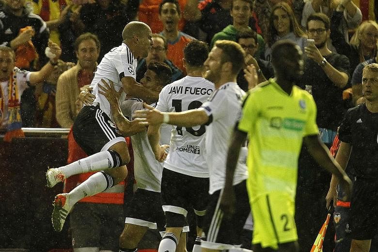 Sofiane Feghouli (left) celebrates after scoring Valencia's first goal in the 2-1 win over Gent. The Spanish side are edging towards the Champions League last 16.
