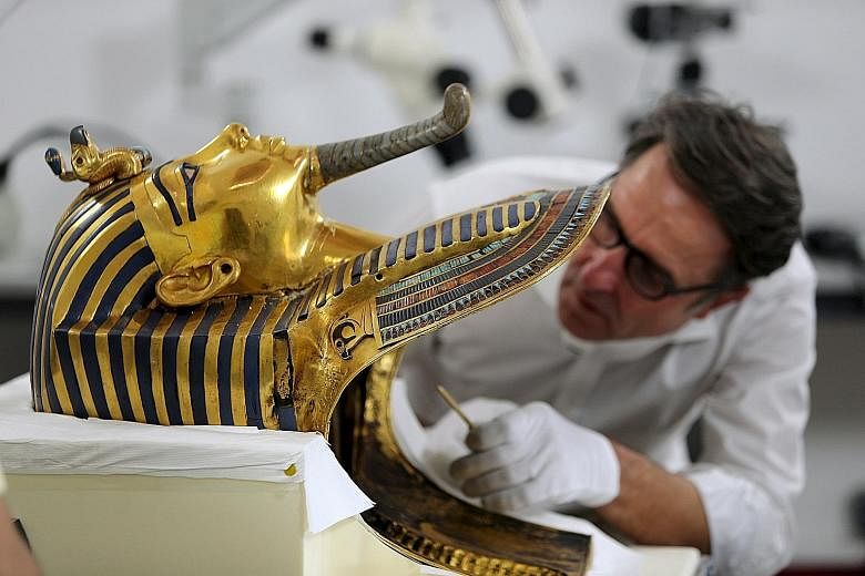 Restoration expert Christian Eckmann working to remove a crust of dried glue from the beard of Tutankhamun's mask in Cairo.