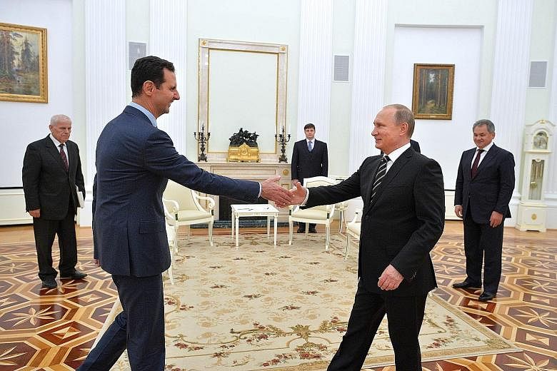 Russian President Vladimir Putin (right) welcoming his Syrian counterpart, Mr Bashar al-Assad, to the Kremlin on Tuesday. It was Mr Assad's first foreign trip since war broke out in Syria.