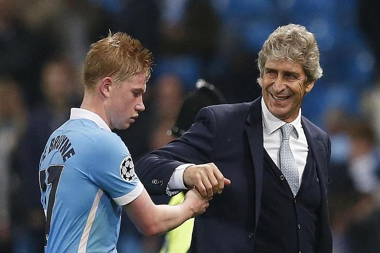 Manchester City's Kevin de Bruyne congratulated by manager Manuel Pellegrini. The club-record signing scored a dramatic stoppage-time winner against Sevilla to seal a 2-1 win.