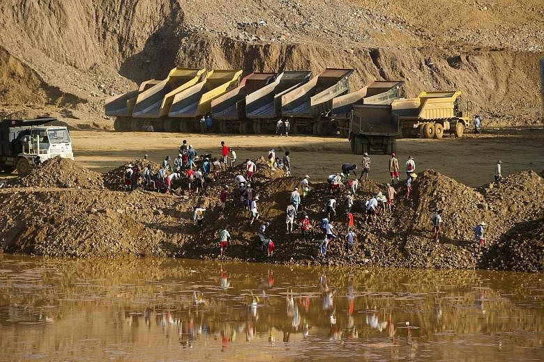 Miners on Oct 4 digging for raw jade stones in piles of waste rubble dumped by mechanical diggers next to a jade mine in Hpakant. The long-running conflict between Kachin and government forces is as much over natural resources as over political and e