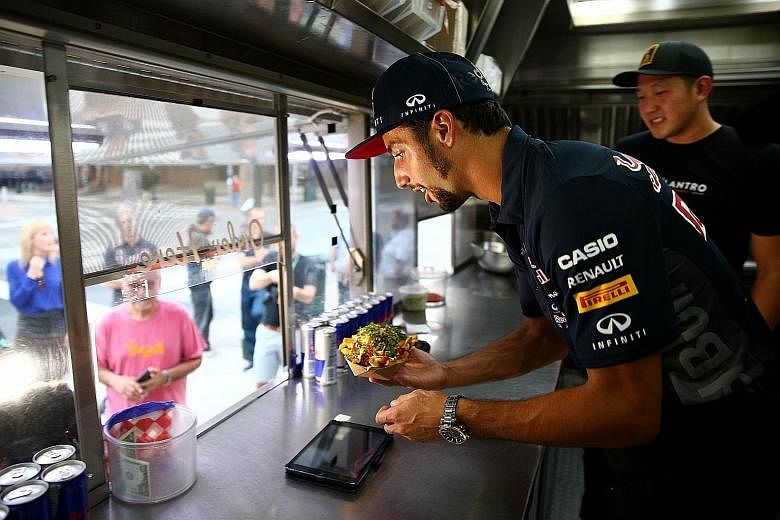 Red Bull driver Daniel Ricciardo of Australia displaying a separate set of skills while serving a customer at a food truck in Austin, Texas, on Thursday.