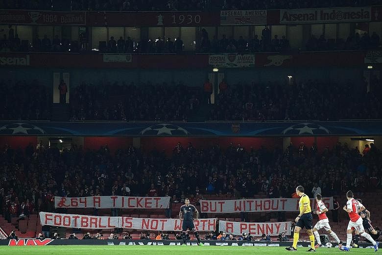 Bayern fans holding a banner in protest against the high cost of tickets, at the beginning of the Champions League match against Arsenal. They had each forked out about S$400 for the entire trip.