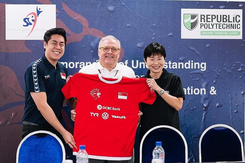 Edwin Ker (left), Singapore Swimming Association (SSA) executive director, and Bob Gambardella (centre), Singapore Sports Institute chief, presenting Goy Soon Lan, Republic Polytechnic's (RP)'s director, School of Sports, Health & Leisure, with a tok