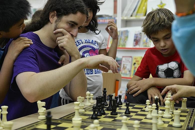 Pupils playing chess with their teacher at a public school in Madrid. Some studies have shown that an hour of chess a week can boost pupils' performance in maths by 30 per cent.