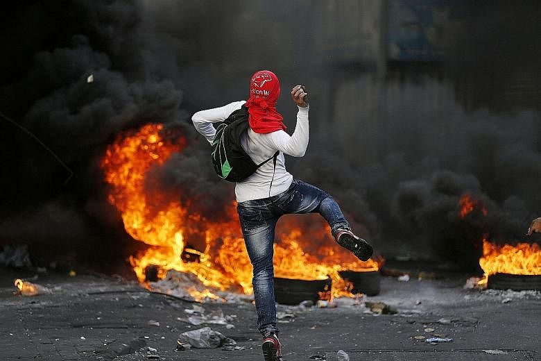 A Palestinian protester hurling stones at Israeli soldiers during a clash in the West Bank city of Hebron this week. About 60 people have been killed in the current wave of violence.