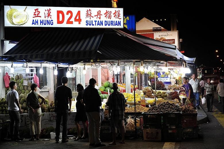 Lining the streets of Geylang are brightly lit fruit shops (above) that offer a unique experience of eating by the roadside, with cars zooming past. Eminent Frog Porridge (below), located in Geylang Lorong 19, is among the many culinary delights the 