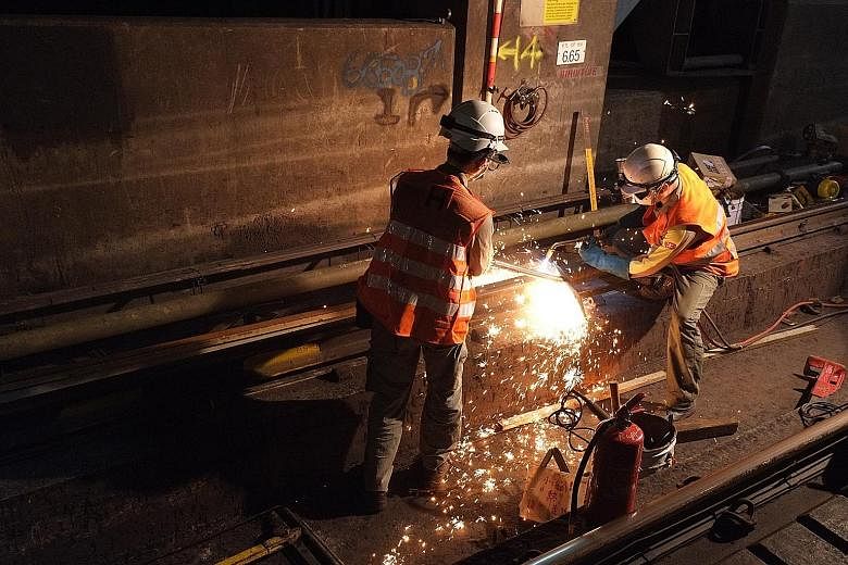 An MTR maintenance crew working to replace a section of rail at Diamond Hill station in the early hours of a Saturday morning. ST PHOTO: LI XUEYING