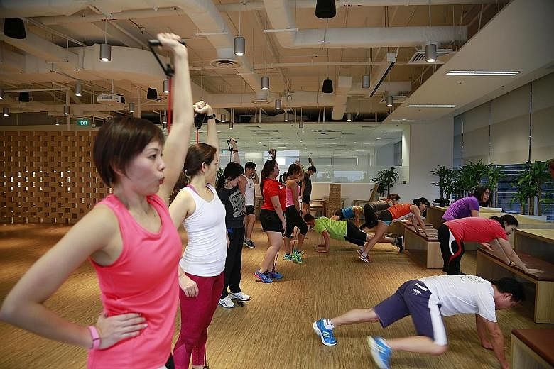 SAP employees, some wearing fitness trackers, exercising at the company's UFit bootcamp, which is held on Mondays.