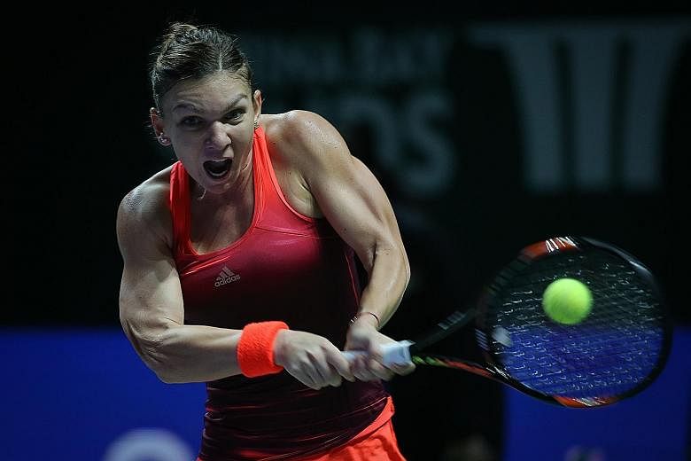 Simona Halep playing a backhand return to Flavia Pennetta in her 6-0, 6-3 win yesterday. The top seed in the WTA Finals aims to go one better than last year when she lost in the final to Serena Williams.