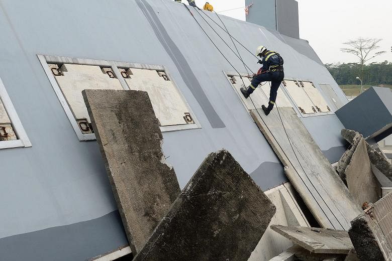 At the new training centre, officers can rappel down the side of a collapsed building (far left), and do confidence jumps into a 9m-deep pool (left). Special Operations Command officers practising a simulated attack at the new drive-in shooting range