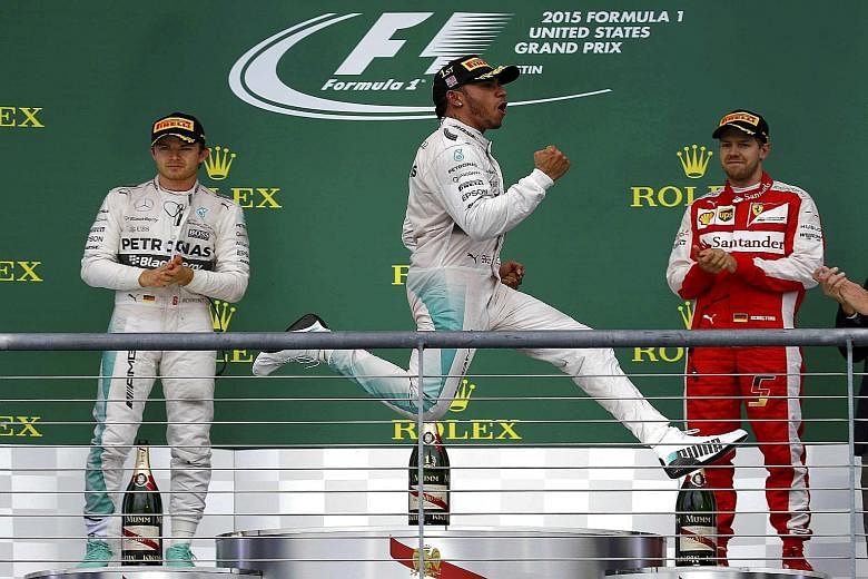British driver Lewis Hamilton celebrating after sealing his third world championship with victory in the United States Grand Prix in Austin, Texas on Sunday. Ferrari's Sebastian Vettel (right) and Hamilton's Mercedes team-mate Nico Rosberg applaud, b