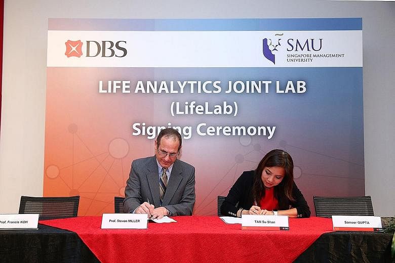 Dr Steven Miller and Ms Tan Su Shan, DBS' group head of consumer banking and wealth management, signing the research lab agreement.