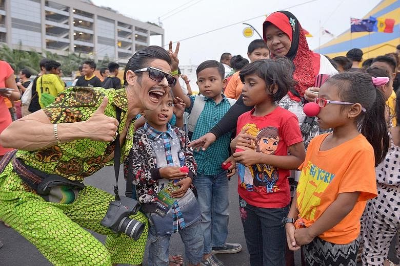 A Cirque du Soleil performer (left) greets some guests. Children and youth from charities such as Beyond Social Services, Brahm Centre, Care and M1 Students Support Fund were treated to the show Totem.