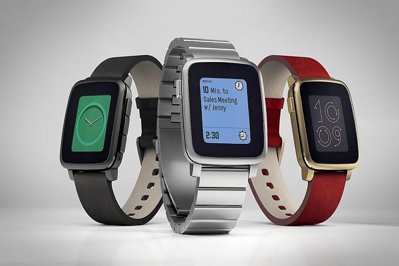 The Pebble Time Steel smartwatch comes in (from left) gunmetal, stainless steel and gold with a red strap.