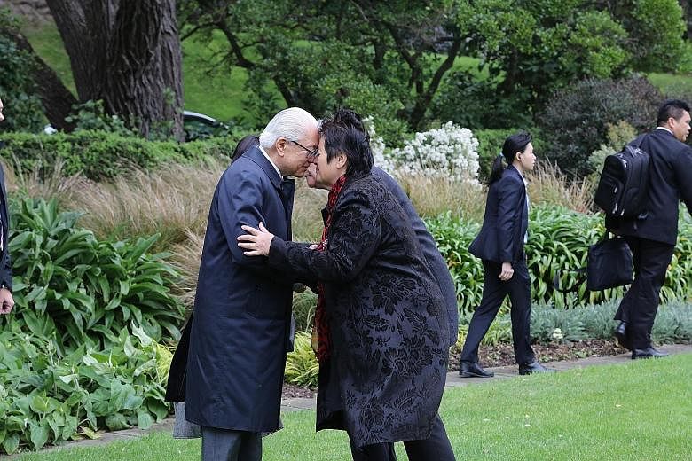 President Tony Tan Keng Yam and Dr Hiria Hape pressing their noses and clasping hands in the traditional Maori greeting known as the hongi during a ceremonial welcome outside Government House in Wellington yesterday. Dr Hape is the Government House k