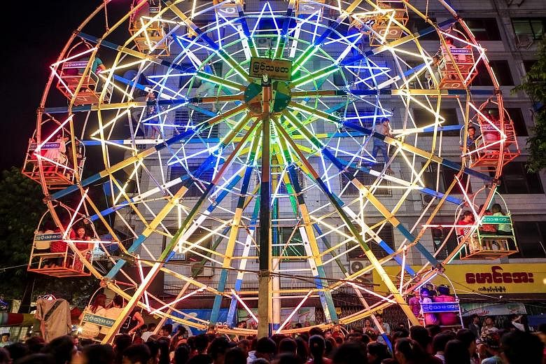 Revellers enjoying a ride on a human-powered ferris wheel during the Thadingyut Festival, or Festival of Lights, in Yangon, Myanmar, on Monday. Gutsy ferris wheel workers spread out across the mammoth structure, as they manually turned the wheel with