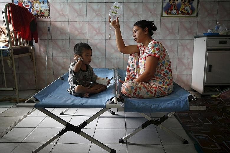 A mother tending to her son, who is recovering from a respiratory illness in a hospital in Palangkaraya, Central Kalimantan, yesterday. The death toll from the haze crisis has risen to 19, including children, in provinces like South Sumatra and Centr