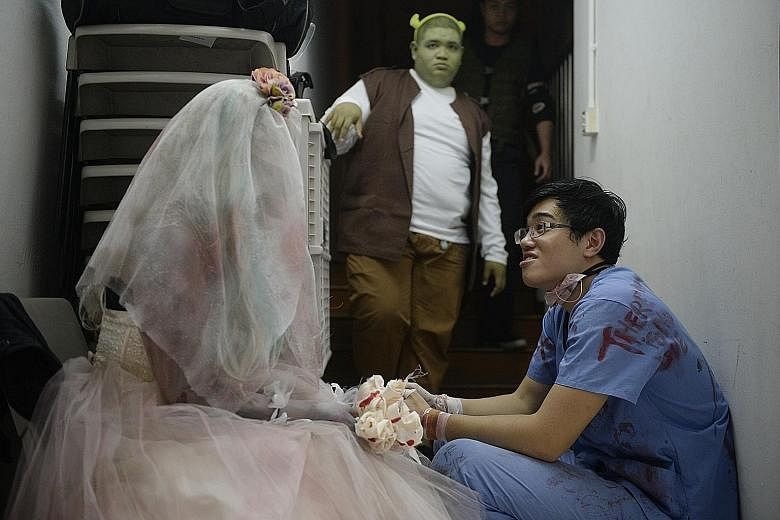 Caleb Tan (right) chats with Danielle Faith Chao, 29, who is dressed as a corpse bride, while Mohamad Taufik Ali, 23, acting as Shrek, stands in the background. Pro-wrestling involves theatrical skill as the shows often have a storyline.