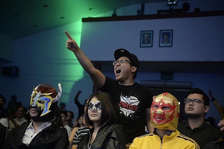A member of the audience reacts to the action in the ring, while others have fun wearing lucha libre (free wrestling, in Spanish) masks while they watch the show. Currently, SPW draws an average of 400 people per show.