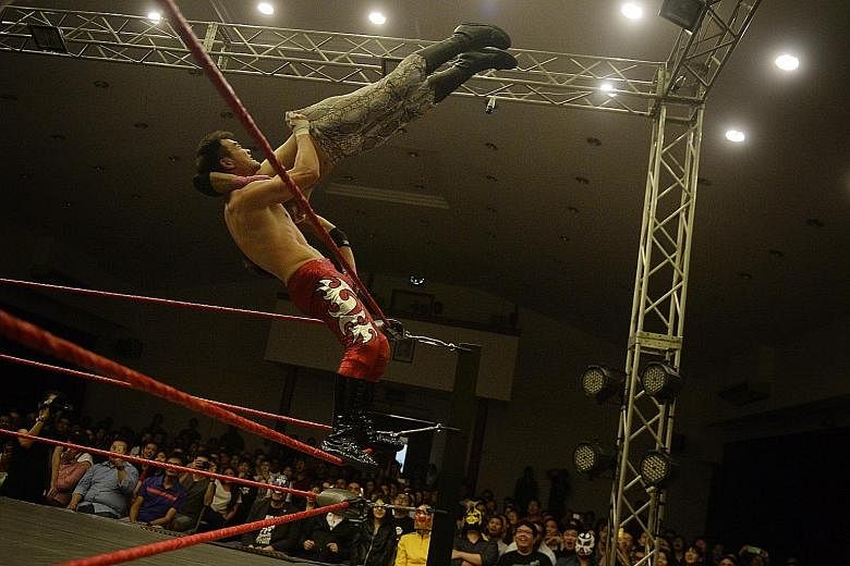 Greg Glorious (Greg Ho), 32, throws The Ladykiller (Dennis Hui) off the top rope. Pro wrestling matches are carefully choreographed and the results are pre-determined.